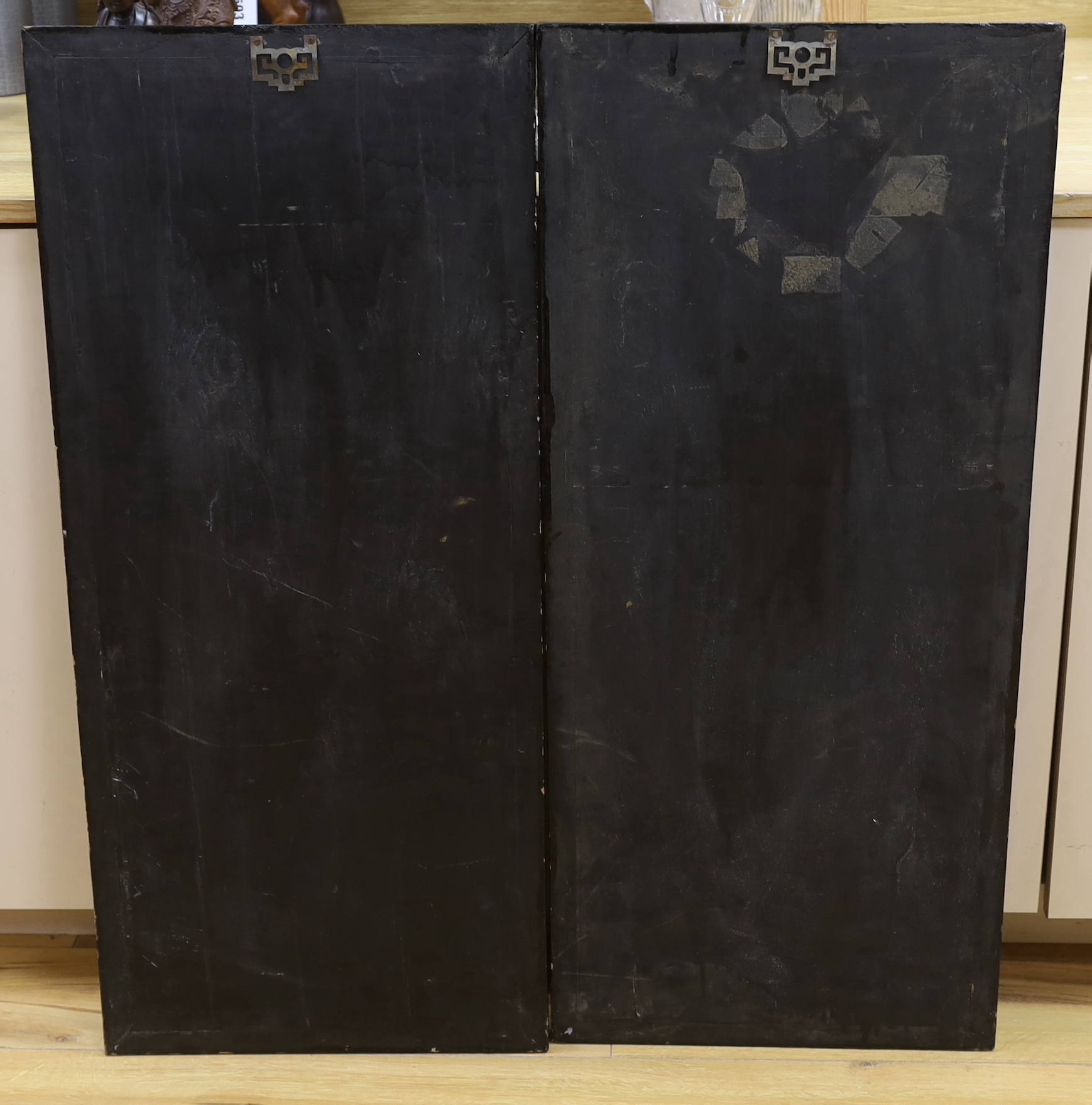 A pair of Chinese black lacquered panels, decorated in relief with females before pagodas, 92cm x 40cm